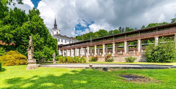 Lysice castle, Czech Republic. Famous baroque castle built in 14th century. Beautiful formal garden, palm trees and flowers. Promenade near the castle. Sunny day, dramatic clouds before storm. - Фото, зображення