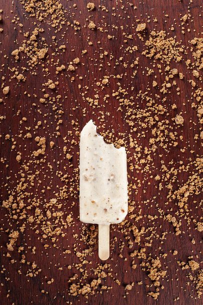 Παγωτό βανίλιας καλυμμένο με λευκή σοκολάτα και γεμάτο με κρέμα φουντουκιού. Γλειφιτζούρι. Άνω όψη - Φωτογραφία, εικόνα