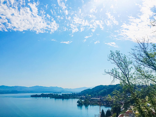 Idyllic Swiss landscape, view of lake Zurich in Wollerau, canton of Schwyz in Switzerland, Zurichsee, mountains, blue water, sky as summer nature and travel destination, ideal as scenic art print - Photo, Image