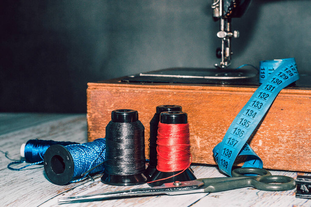 Sewing accessories sewing machine, colored threads, as well as scissors and measuring tape - Foto, imagen