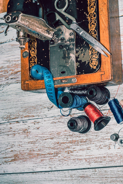 Швейна фурнітура швейна машина, кольорові нитки, а також ножиці та вимірювальна стрічка
 - Фото, зображення