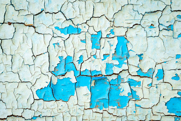 Текстура тріщин синьо-білої фарби на дерев'яній поверхні. Фон старих дверей з пілінговою фарбою
. - Фото, зображення