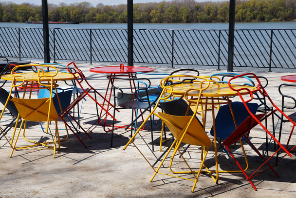 mesas plegadas y sillas en un café de la calle en el terraplén del Danubio. - Foto, Imagen