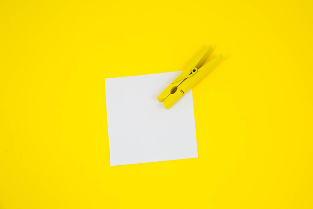 Blank white To Do List Sticker with yellow wooden clothespin. Close up of reminder note paper on the yellow background. Copy space. Minimalism, original and creative photo. - Photo, image