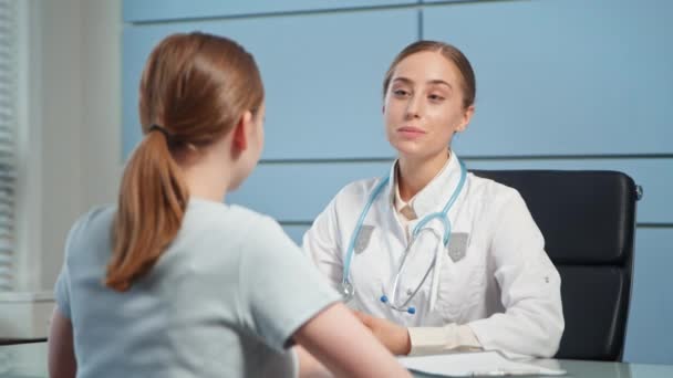 Κυρία γενική ιατρός και νεαρή γυναίκα ασθενής μιλούν - Πλάνα, βίντεο