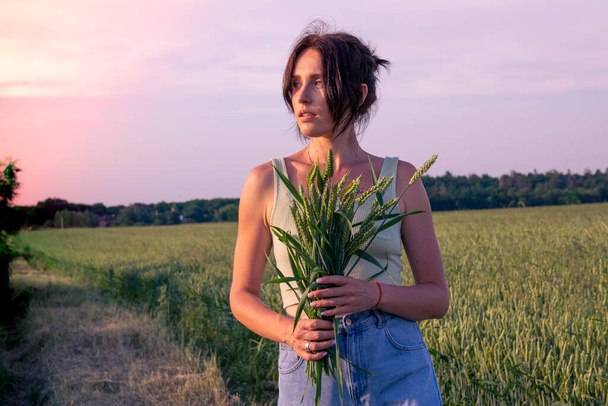 Menina branca bonita em um campo de trigo com um buquê de orelhas de trigo - Foto, Imagem