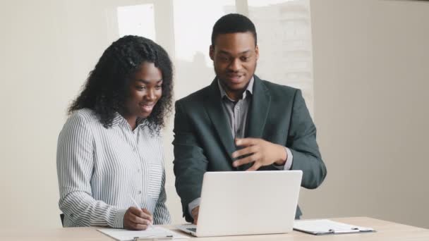Szczęśliwy różnorodny młodych kolegów zawodowych Afrykańskie pochodzenie etniczne przy użyciu oprogramowania komputerowego businesswoman i biznesmen omawiając projekt online pracując razem na laptopie na spotkaniu biznesowym - Materiał filmowy, wideo