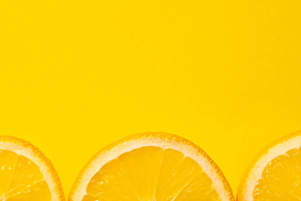 Découpé orange, fond jaune, espace de copie. Fruits frais juteux, source de vitamine C. Fond lumineux. - Photo, image