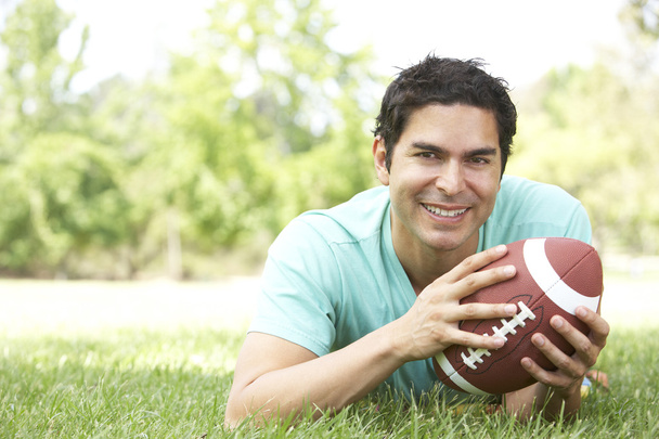 Portrait Of Young Man In Park With American Football - Foto, immagini
