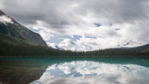 Panoramische opname van ongerepte alpine meer omgeven door bos gemaakt bij Emerald Lake, Yoho National Park, British Columbia, Canada - Foto, afbeelding