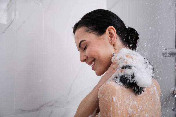 Fiatal nő hálós púppal otthon zuhanyozik. A szöveg helye - Fotó, kép