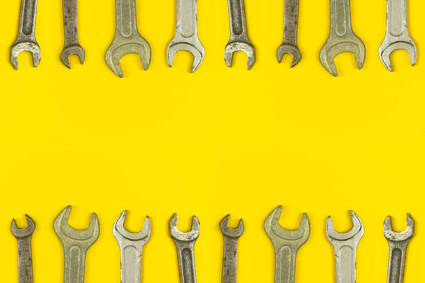 Various wrench tools border backround, yellow worker table workspace concept, top view and copy space  - Photo, Image