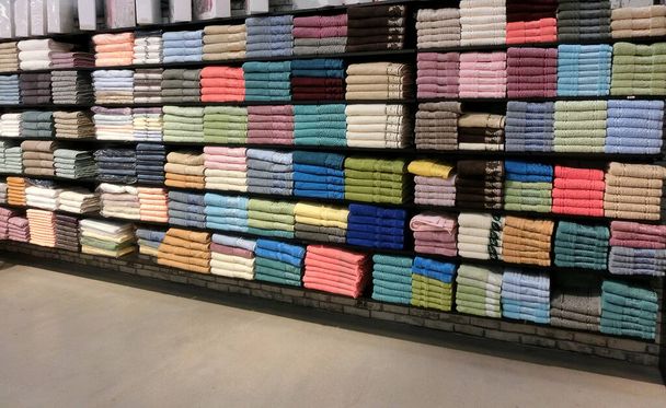 Las alfombras turcas están a la venta en la tienda. Los productos yacen reducidos en los estantes de la tienda - Foto, Imagen