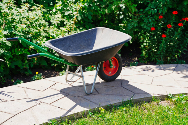 New plastic and Metal Garden Trolley in a botanical garden. Garden works, in the part of the flower garden - Photo, Image