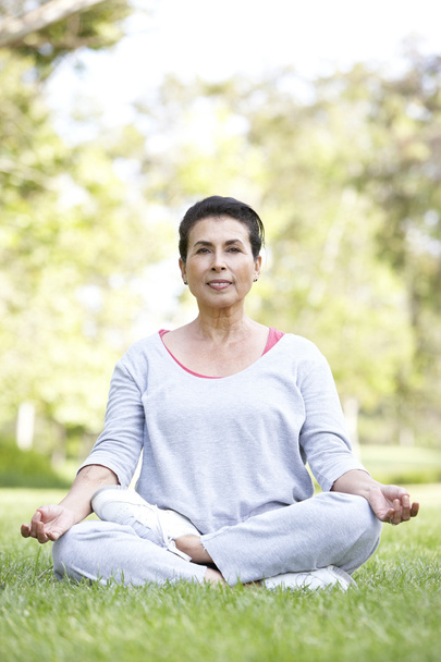 Senior Woman Doing Yoga In Park - Foto, imagen