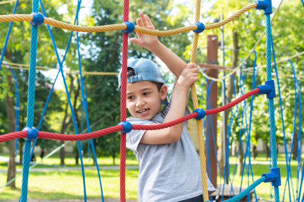 7-летний мальчик играет на детской площадке летом. - Фото, изображение