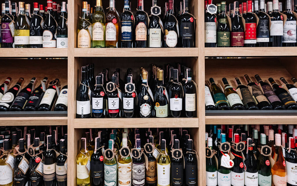 Minsk, Belarus - July 03, 2021: Various wine bottles sale on the wooden shelf in a supermarket shop. - Foto, Imagen