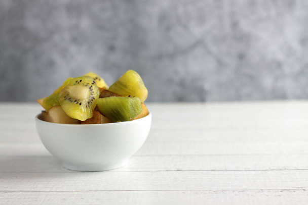 a bowl of fruit salad isolated on white wooden background. Image contains copy space - Valokuva, kuva