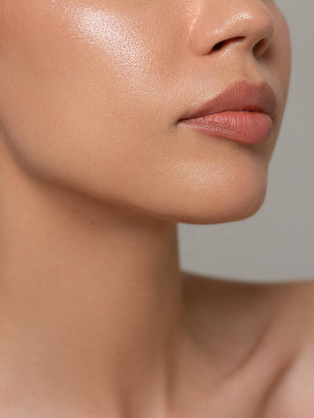 Sexual full lips. Natural gloss of lips and woman's skin. The mouth is closed. Increase in lips, cosmetology. Pink lips and long neck. - Foto, Imagen