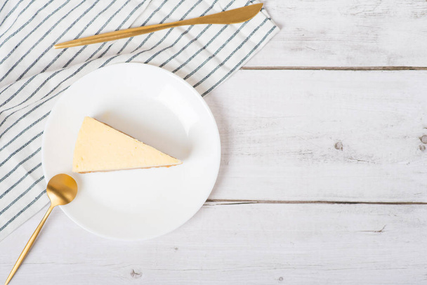 Cheesecake clássico em uma mesa de madeira branca. Cheesecake de Nova York ou cheesecake clássico com bagas frescas no prato branco - Foto, Imagem