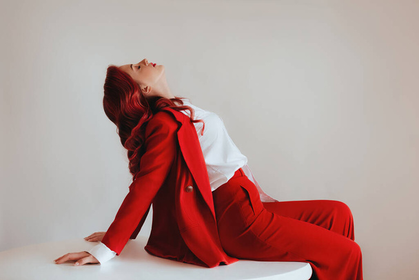 Gorgeous woman  in an elegant red suit with red hair . Natural female beauty. - Φωτογραφία, εικόνα