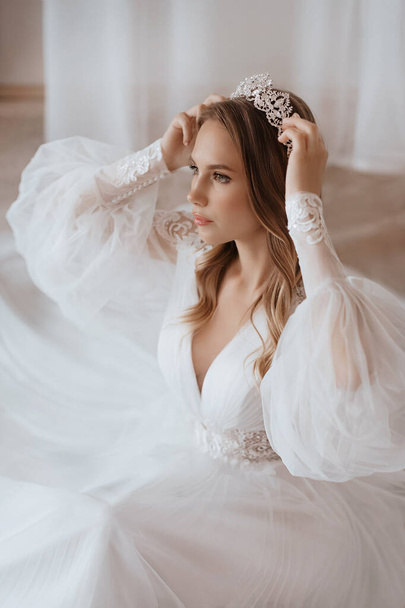 Beautiful brunette bride with light make-up in white dress  in an exquisite interior  - Foto, imagen