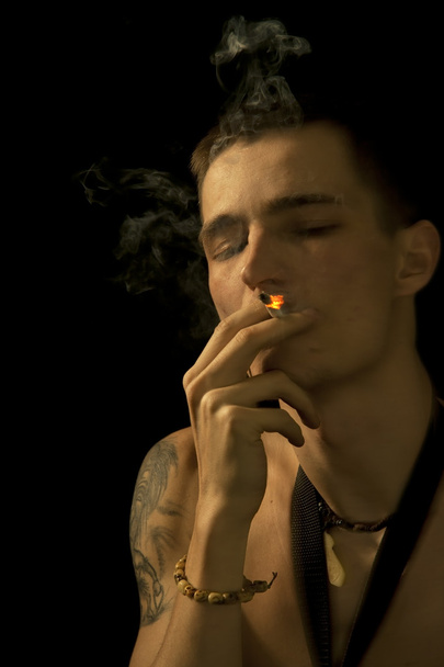 Tupakointi nuori mies sulki silmänsä
 - Valokuva, kuva