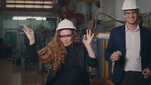Happy heavy industry business engineering and manager in hardhats dancing funny together indoors welding manufacturing industrial factory after success project, - Valokuva, kuva