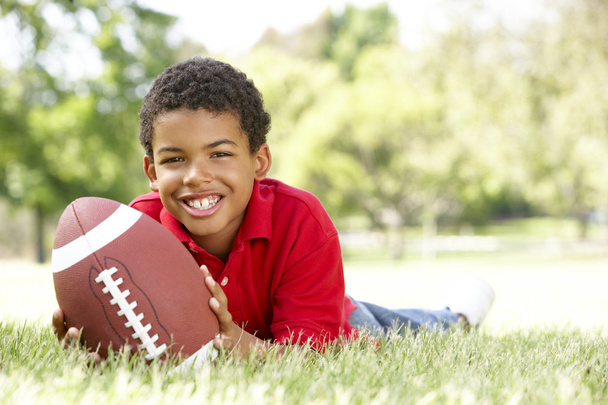 Boy In Park With American Football - Valokuva, kuva
