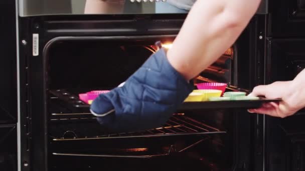Uma mulher puxa uma assadeira com bolos no forno - Filmagem, Vídeo