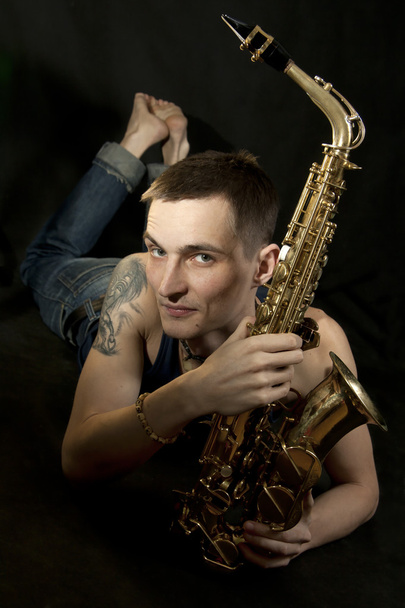 młody jazzman Połóż się na podłodze z saksofon - Zdjęcie, obraz