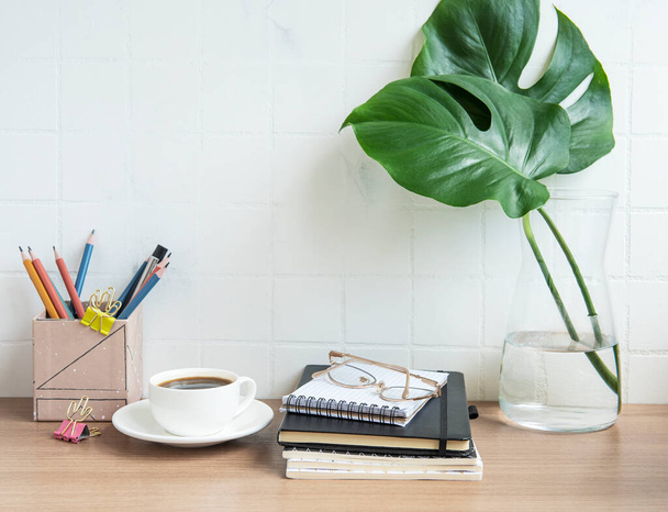 ノート、電源、コーヒーカップ付きのオフィスデスクテーブル. - 写真・画像