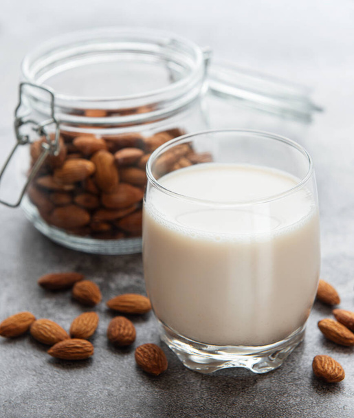 Glass with almond milk and almonds on the table - Foto, immagini