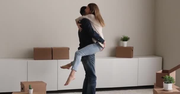 Husband lift wife on arms swirling celebrate relocation day - Felvétel, videó
