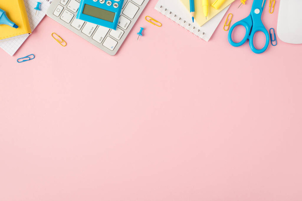 Foto vista superior de los organizadores de papelería azul y amarillo marcadores de lápiz clips pinzas tijeras pegatinas calculadora teclado ratón sobre fondo rosa pastel aislado con copyspace - Foto, Imagen