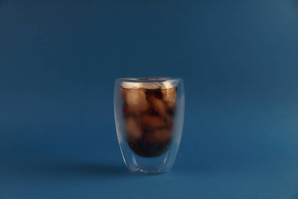 Refreshing drink - glass of ice cola isolated on blue background - Фото, зображення
