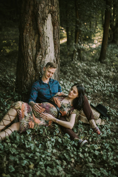 Happy family, pregnant woman and handsome man, resting on a walk in beautiful summer forest - Foto, Imagem