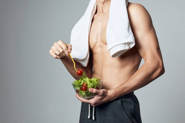uomo sportivo con piatto muscoloso di insalata su un sano allenamento alimentare - Foto, immagini