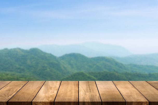 Holztischplatte mit Natur Berg und Wald verschwimmen Hintergrund. Kopieren Sie Platz für Ihr Display- oder Montageproduktdesign. - Foto, Bild