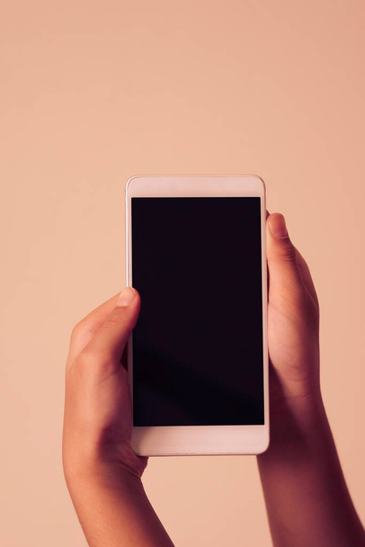 Концепція бізнесу: молодий чоловік тримає смартфон з порожнім екраном на білому тлі, крупним планом, рекламний текст, що продає маркетингові продукти, сміється, простір для тексту
. - Фото, зображення