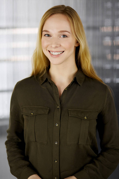 Friendly adult casual dressed business woman standing straight. Business headshot or portrait in office - Foto, imagen