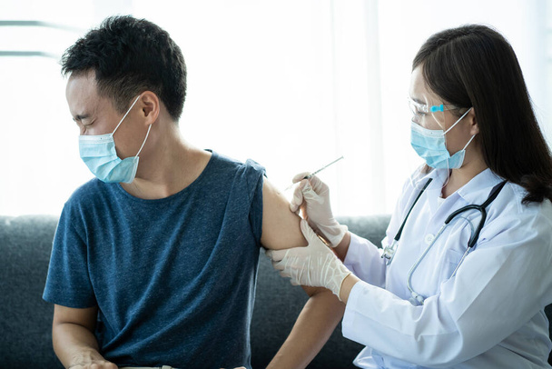 Asian young man very scare a vaccination shot, man having a needle phobia problem and feared while shooting a vaccine. - Foto, immagini