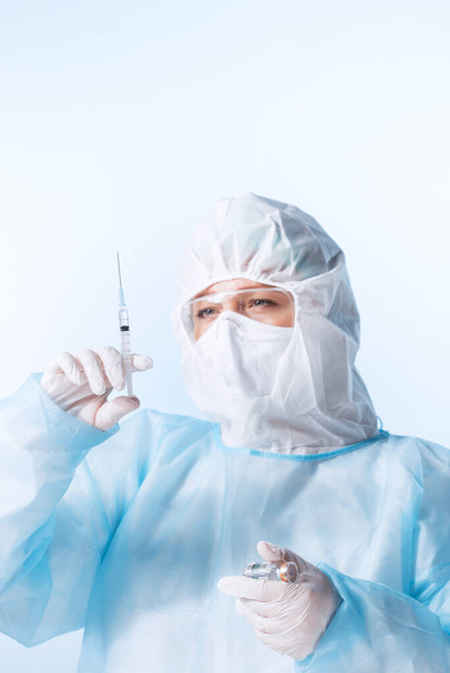 Közelkép az orvosról a kék háton lévő kovid vakcina fecskendőjével - Fotó, kép