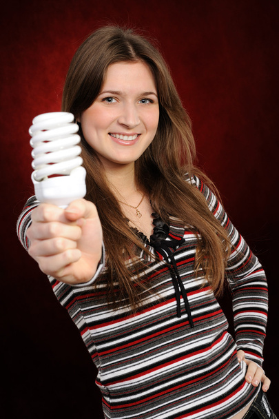 Mulher segurando uma lâmpada fluorescente
 - Foto, Imagem