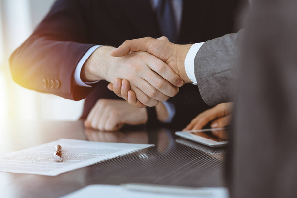 Handshake as successful negotiation ending, close-up. Unknown business people shaking hands after contract signing in modern office - Фото, изображение