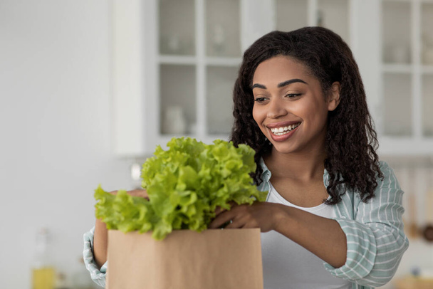 Frau sortiert nach dem Einkauf Bio-Lebensmittel. Online-Einkauf und Lieferung Lebensmittelgeschäft - Foto, Bild