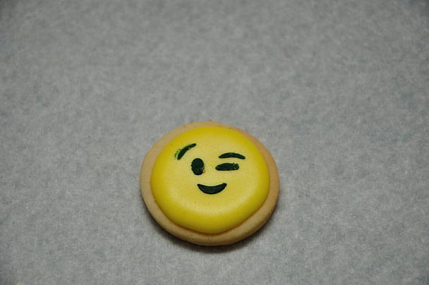 Um biscoito emoji sorridente em um fundo branco - Foto, Imagem