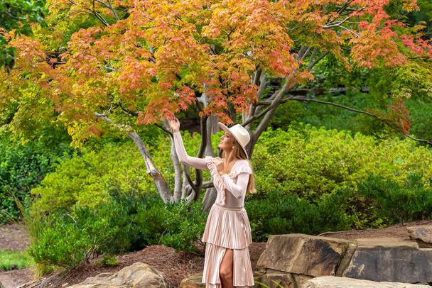 Sonbahar kıyafetleriyle dışarıda poz veren güzel bir sarışın manken. - Fotoğraf, Görsel