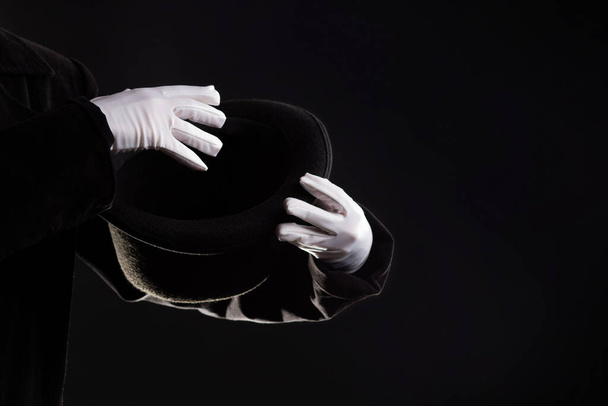 Hand gestures. illusionist holds a hat in his hands and shows magic and tricks. - Foto, afbeelding