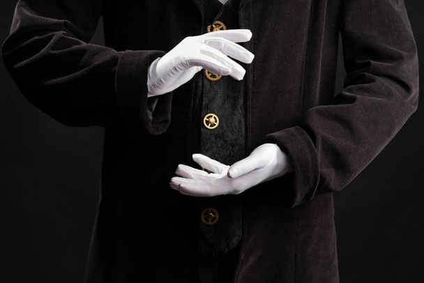 Hand gestures. Showman or magician illusionist in white gloves on a black background. - Foto, immagini